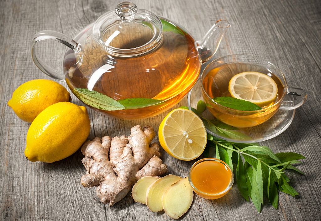 Cup of ginger tea with honey and lemon on wooden table