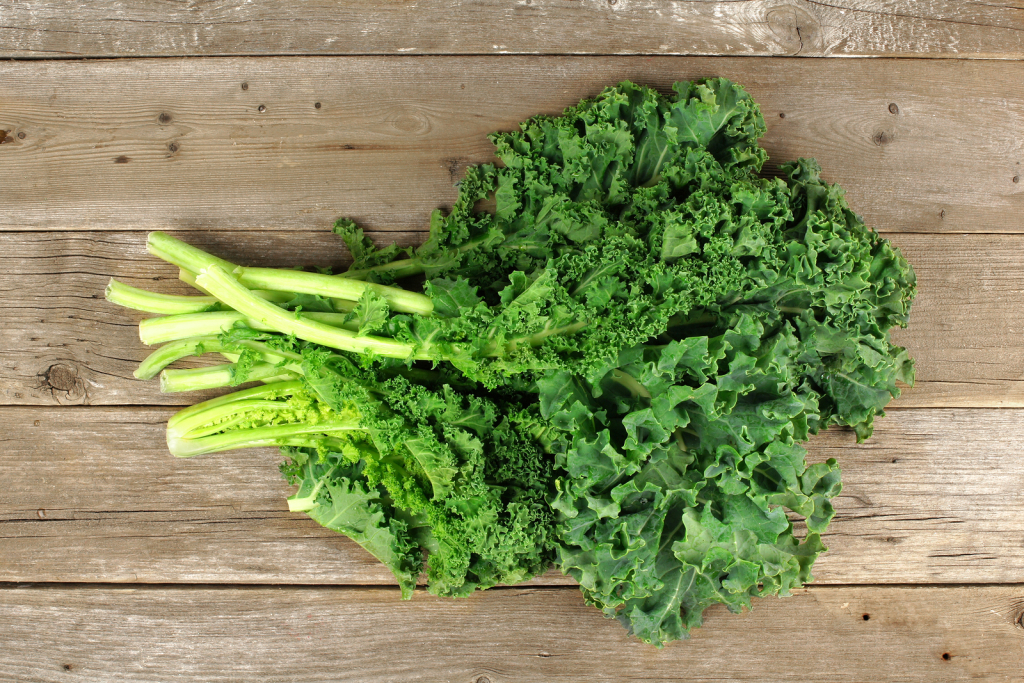 Bunch of fresh kale over a wooden background. Overhead view.